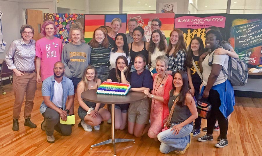 Group of young people standing in front of their murals