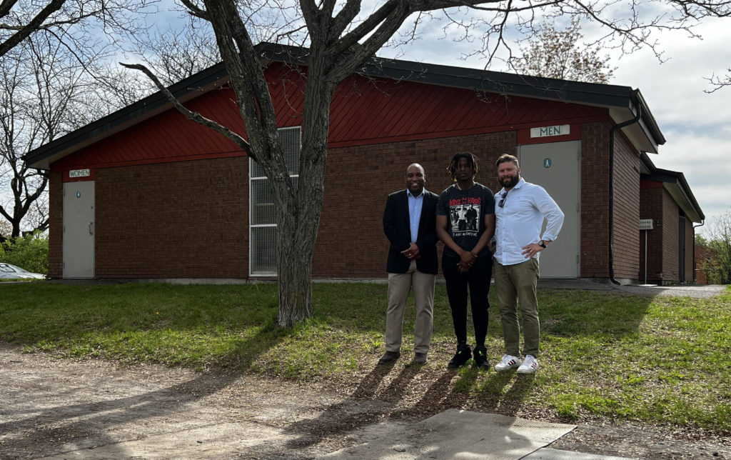 Le conseiller Rawlson King, Josue Basubi et le directeur général de Youth Ottawa Jesse Card se tiennent à l'extérieur du centre (de gauche à droite)