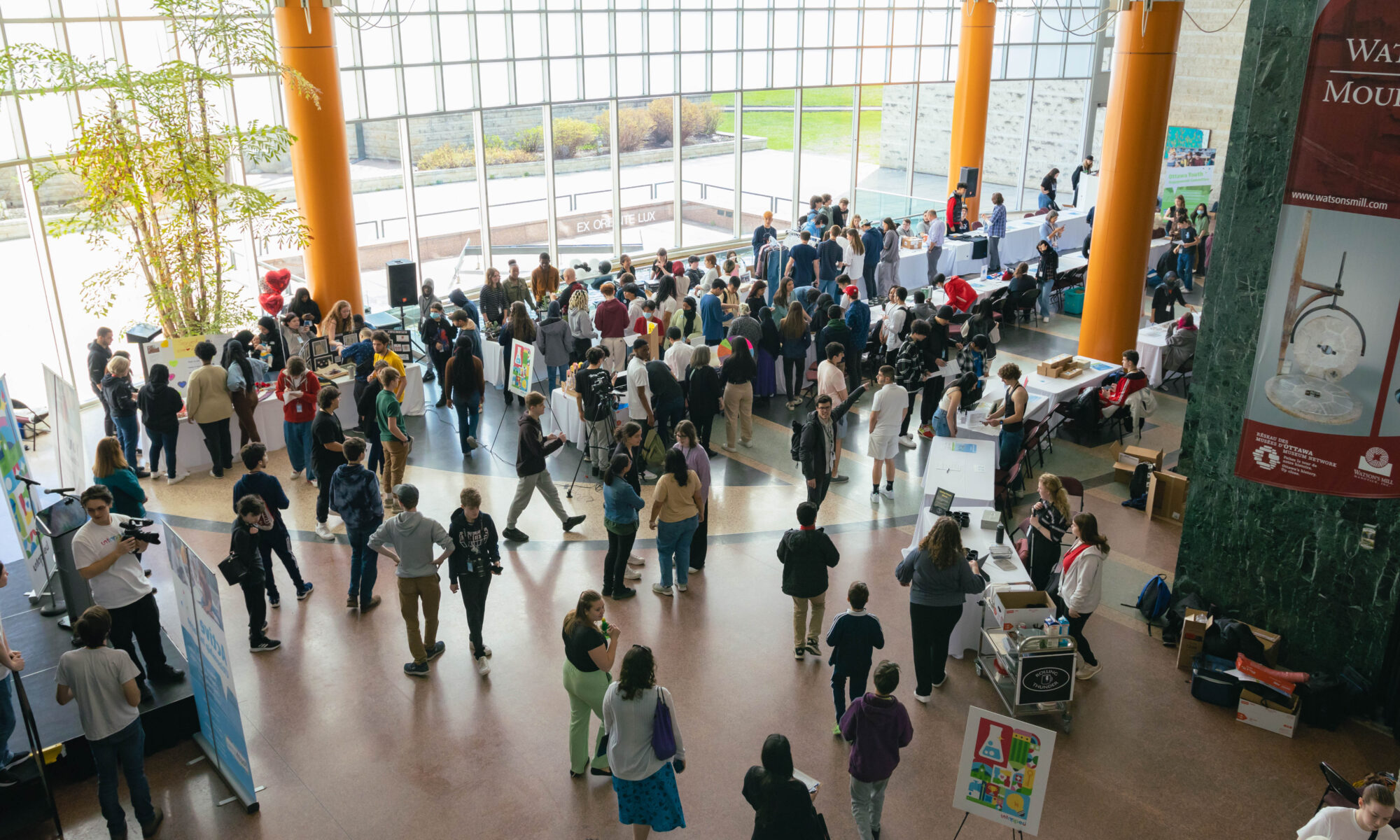 Overhead view of Ottawa City Hall during the Youth Action Untapped Showcase, there are around 100 people pictured